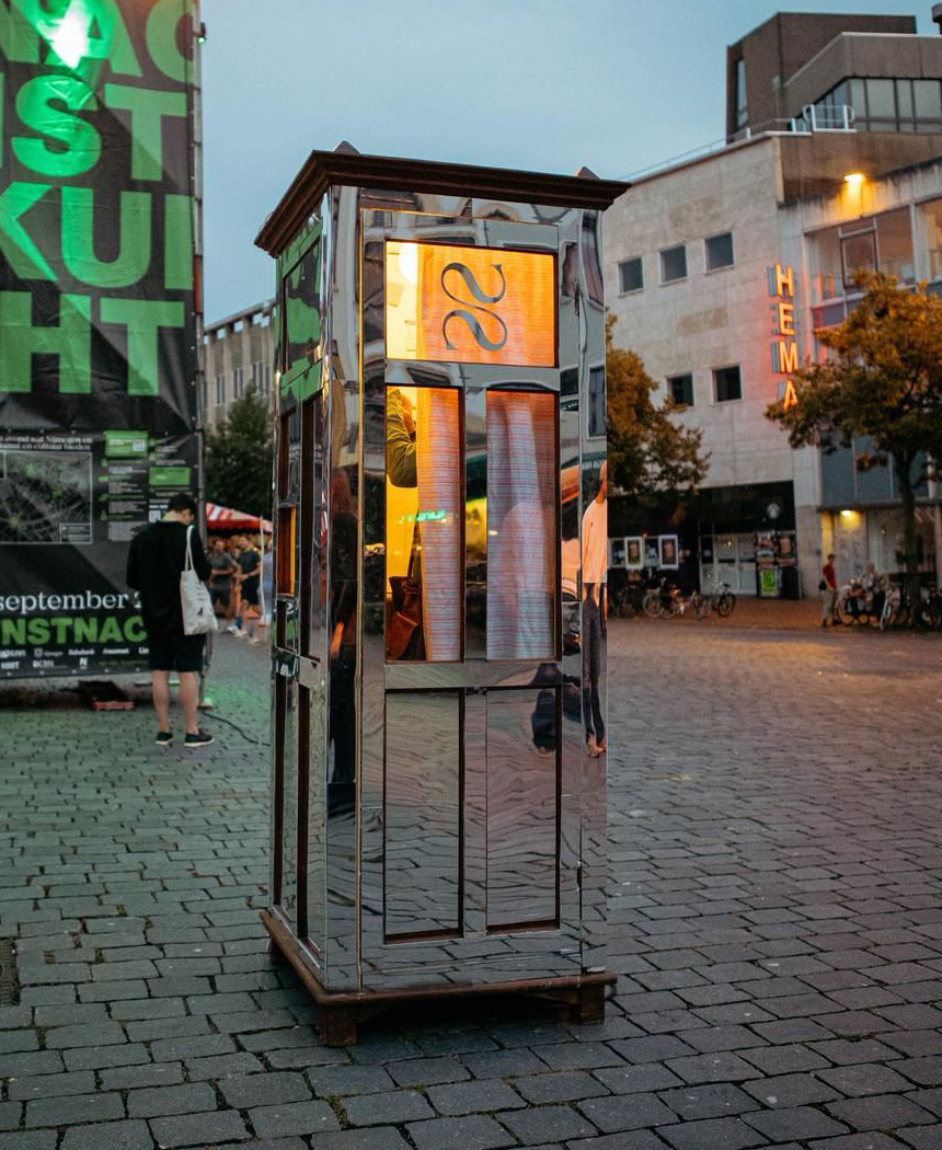 Mirrored booth in the square at dusk