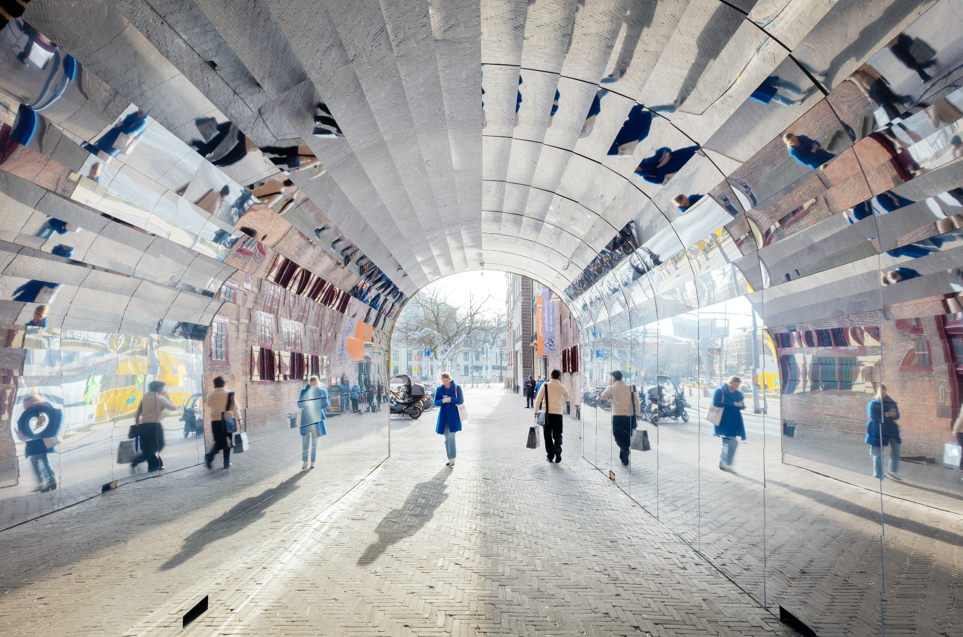 People walk through the mirrored passage at the Gevangenpoort