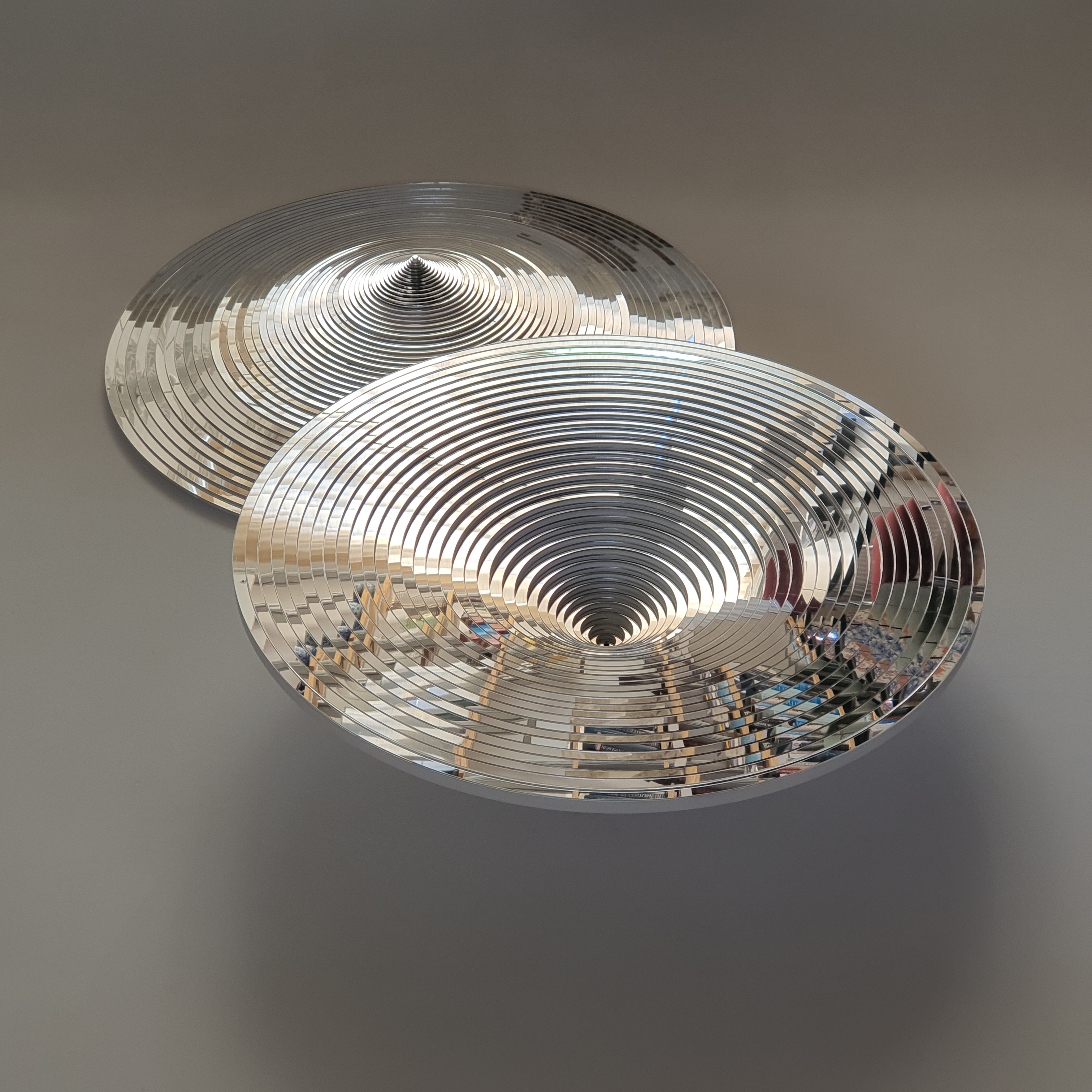Two circular mirrored works on a wall