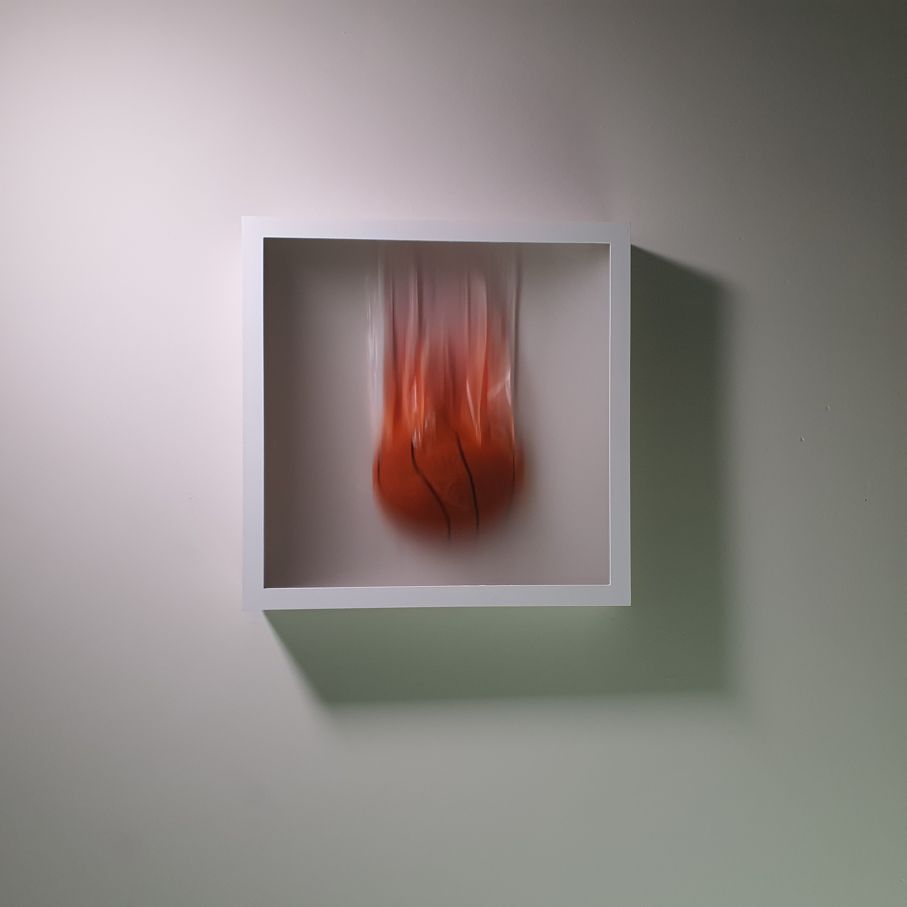 Red object in motion displayed in a white frame