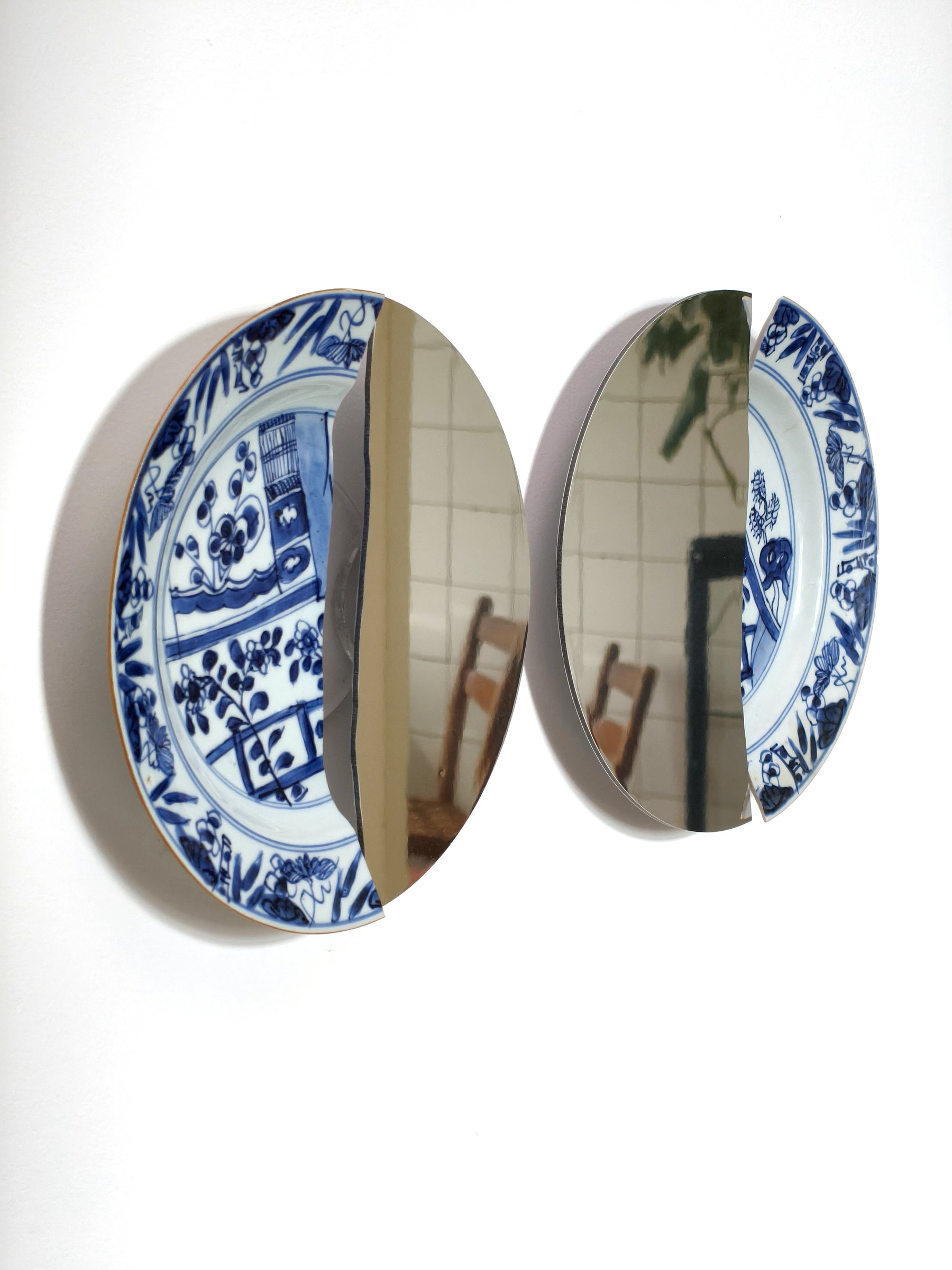 Pair of blue and white porcelain plates with mirrored openings