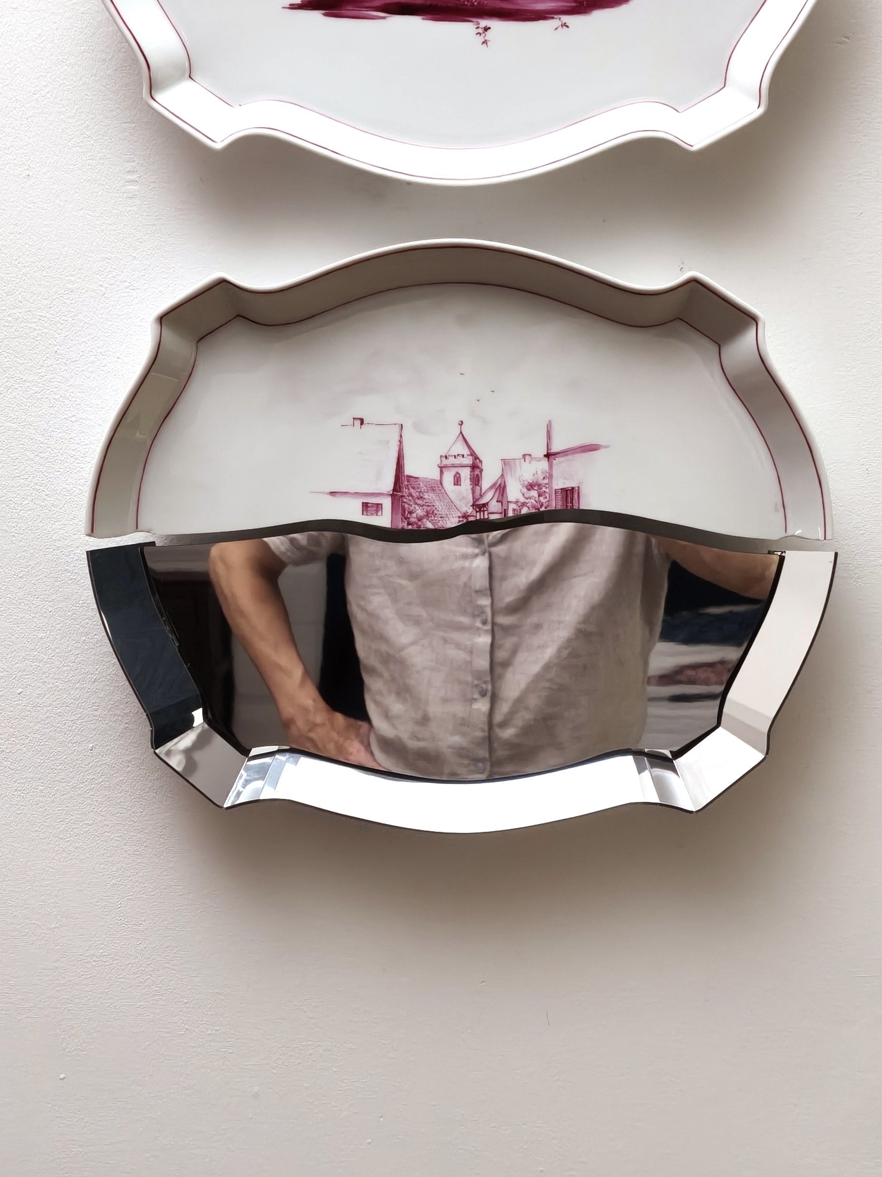 Closer view of mirrored porcelain pieces and their reflection